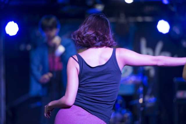 ライブでダンスを披露する女性ダンサーの後ろ姿
