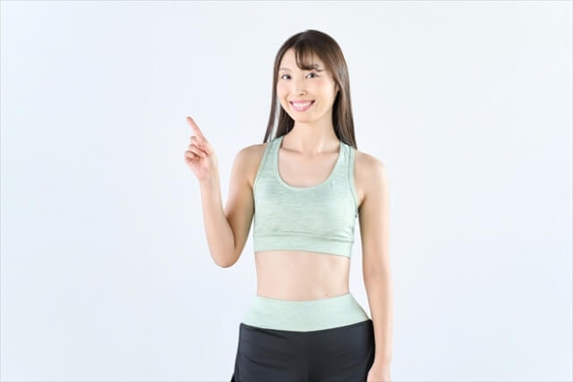 指をさすスポーツウェアの女性